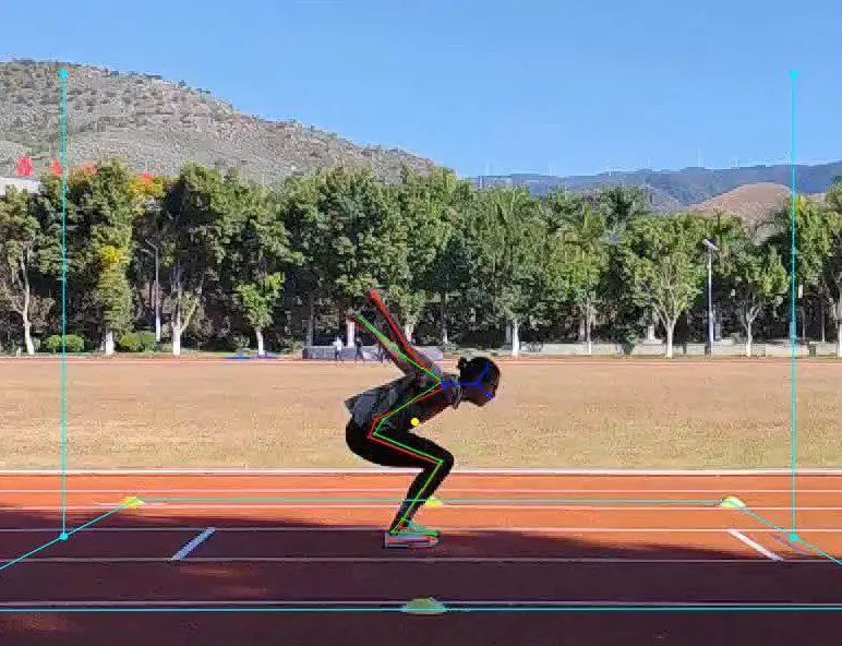 Athlete preparing to jump on a track field under clear blue sky.