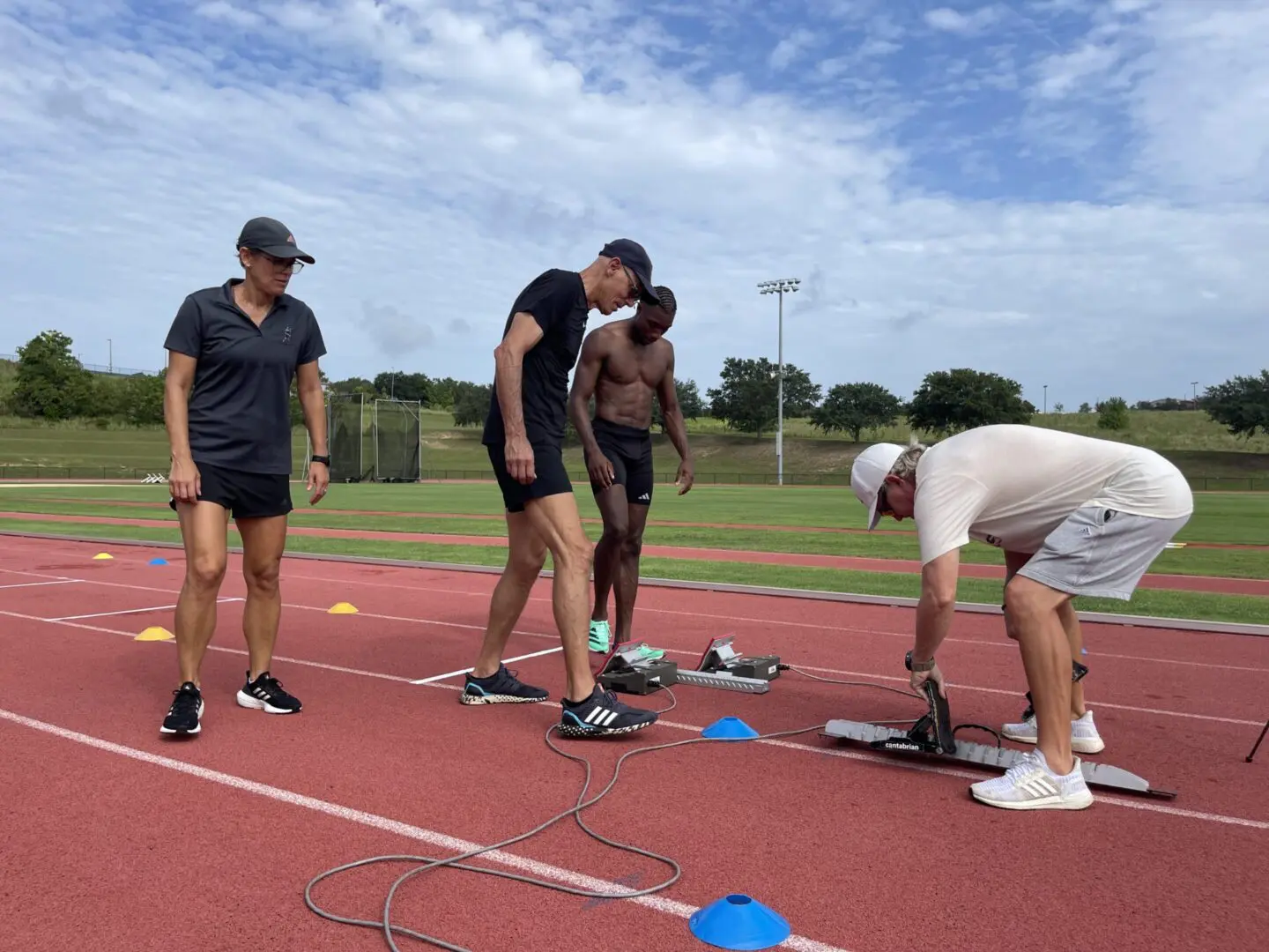 Group of people preparing for a track and field event on a sunny day.
